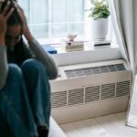 Depressed woman sitting with her head in her hands, showing stress and emotional struggle related to addiction decisions.