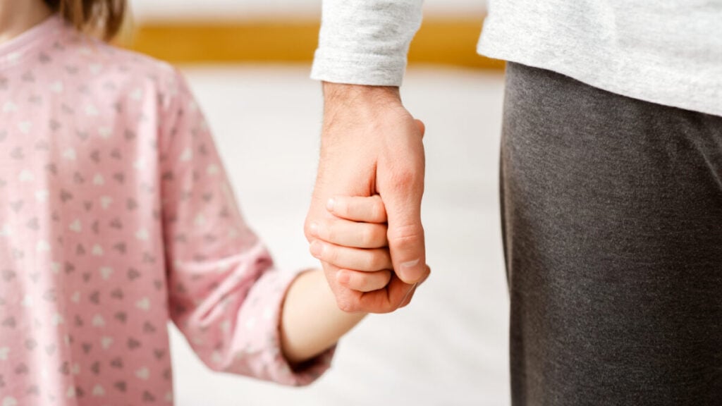 "Parent and child holding hands, representing the importance of child safety in custody cases involving alcohol abuse."