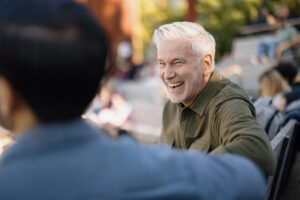 Two men talking and laughing outdoors while rebuilding trust after relapse