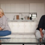 Married couple sitting apart while facing challenges related to drug addiction.